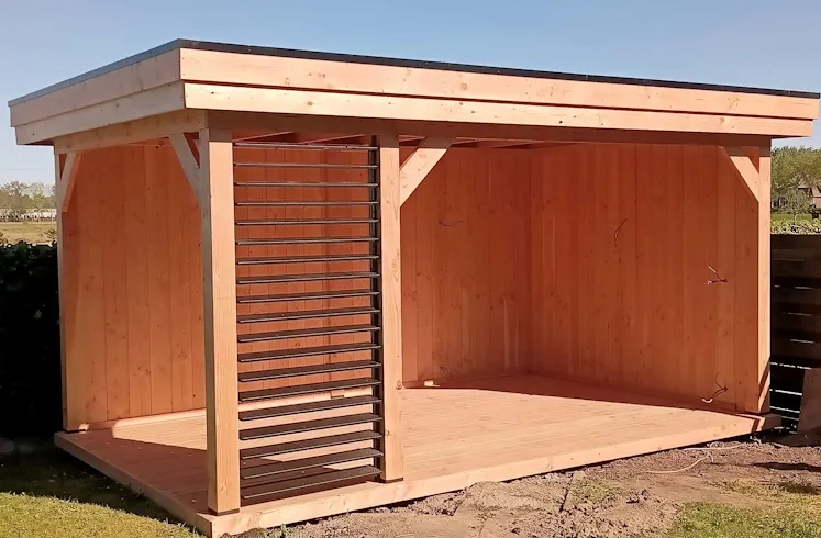 Douglas overkapping met plat dak, houten wanden aan de binnenkant en een shutter aan de voorkant, op een houten vlonder